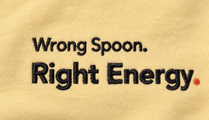 Close-up of the Wrong Spoon. Right Energy. embroidery with orange-red full stop on Butter fabric