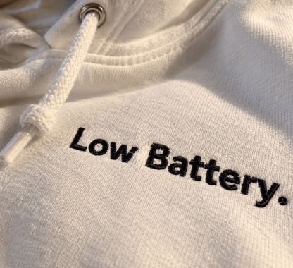 Close-up of black Low Battery. embroidery on the white hoodie