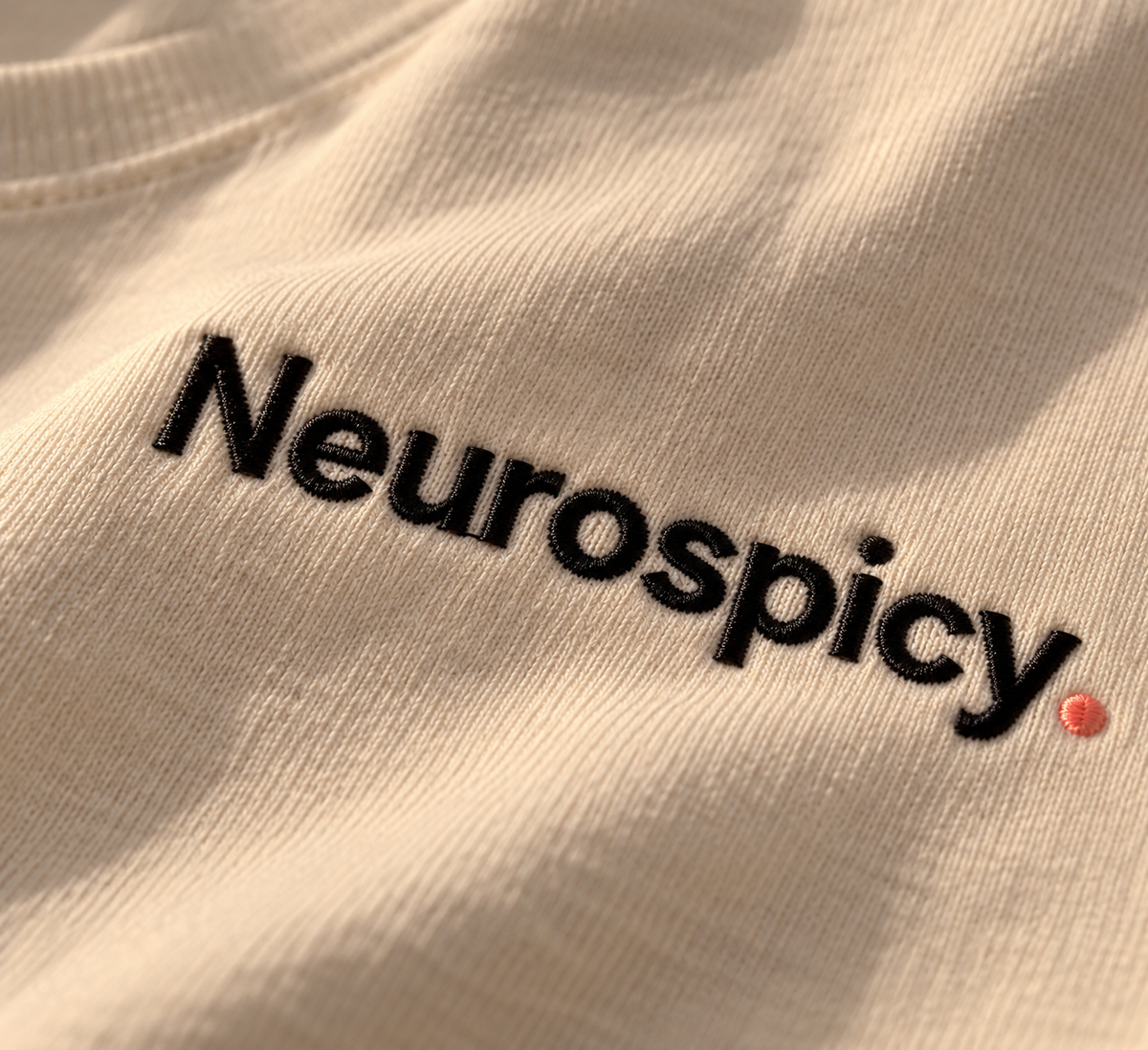 Close-up of black Neurospicy. embroidery on Vintage White fabric