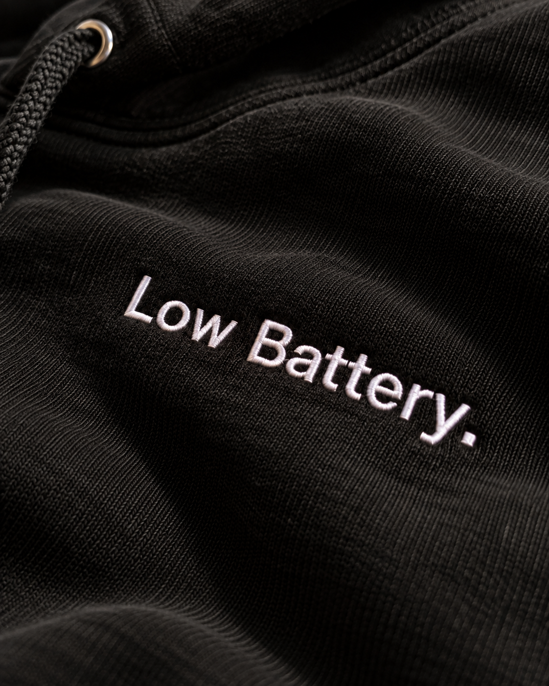 Close-up of the Low Battery. embroidery on the black hoodie