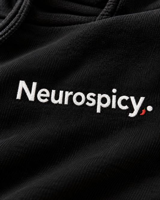 Close-up of the Neurospicy. embroidery on the black hoodie