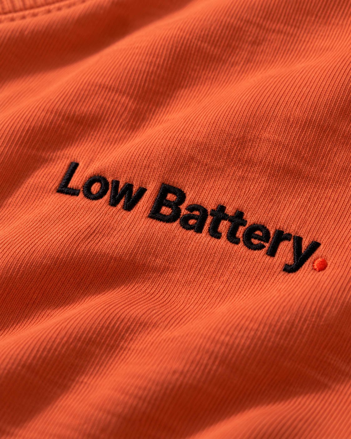Close-up of the Low Battery. embroidery on Terracotta fabric